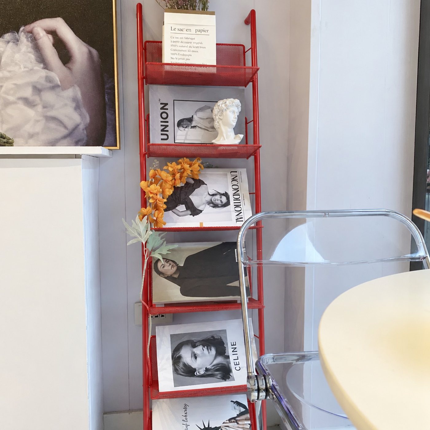 The Lean Rack in red, leaning on a wall with magazines face out